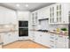 Well-lit kitchen featuring white cabinets, granite countertops, and stainless steel appliances at 572 N Church St, Charlotte, NC 28202