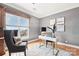 Modern office space with gray walls, wood floors, large window with city views, desk and cushioned chair at 572 N Church St, Charlotte, NC 28202