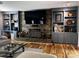 Cozy living room featuring a stone accent wall, built-in shelving, and hardwood floors at 591 Bent Oak Trl, Concord, NC 28027