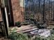 Brick patio with outdoor seating surrounded by lush greenery and a wooden fence at 591 Bent Oak Trl, Concord, NC 28027