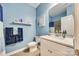 Bathroom with blue painted walls, toilet, sink, mirror, and tiled shower/tub at 611 N York St, Gastonia, NC 28052