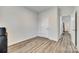 Bedroom with laminate flooring, a window, and doorway view into the hallway at 611 N York St, Gastonia, NC 28052