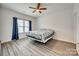 Bright bedroom with ceiling fan, window and curtains, and light, neutral-toned laminate flooring at 611 N York St, Gastonia, NC 28052