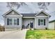 Charming gray home with black shutters, inviting front porch and well-maintained landscaping at 611 N York St, Gastonia, NC 28052