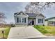 Charming home featuring a gray facade, black door, and a concrete driveway at 611 N York St, Gastonia, NC 28052