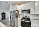 Contemporary kitchen featuring white cabinets, stainless steel appliances, and modern lighting at 611 N York St, Gastonia, NC 28052
