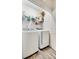 Bright laundry room featuring a white front-loading washer and dryer, floating shelf, and wood-look floor at 611 N York St, Gastonia, NC 28052