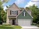 Two-story home featuring a two-car garage, stone accents, and a mix of vertical and shingle-style siding at 6271 Fairfax Ct, Maiden, NC 28650