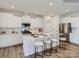Well-lit kitchen featuring an island with seating, white cabinetry, and stainless steel appliances at 6271 Fairfax Ct, Maiden, NC 28650