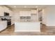 Modern kitchen featuring white cabinets, stainless steel appliances, a large center island, and wood-look flooring at 6277 Fairfax Ct, Maiden, NC 28650