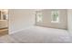 Bright primary bedroom with plush carpeting, two windows, and an en-suite bathroom entrance at 6277 Fairfax Ct, Maiden, NC 28650