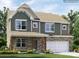 Charming two-story home with a stone facade, complemented by a well-manicured lawn and colorful flowers at 6289 Fairfax Ct, Maiden, NC 28650