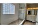Bright bathroom with a modern glass walk-in shower, glass block window, and dual sink vanity at 8703 Ellington Park Dr, Charlotte, NC 28277
