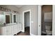 Bathroom features double sink vanity, modern lighting, and entry to water closet at 8703 Ellington Park Dr, Charlotte, NC 28277
