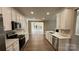 Open-concept kitchen with white cabinets, stainless steel appliances, and seamless flow into the living area at 8703 Ellington Park Dr, Charlotte, NC 28277