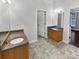Bathroom with double vanities, a decorative light fixture, and separate entrances to the hall and another room at 11124 Chastain Parc Dr, Charlotte, NC 28216