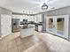Well-lit kitchen featuring stainless steel appliances, a kitchen island, white cabinets, and french doors to the backyard at 11124 Chastain Parc Dr, Charlotte, NC 28216