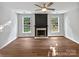 Spacious living room with hardwood floors, a decorative fireplace, and an abundance of natural light from windows at 11124 Chastain Parc Dr, Charlotte, NC 28216