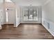 Empty living room with wood floors, white trim, and abundant natural light from the large window at 11124 Chastain Parc Dr, Charlotte, NC 28216