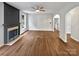 Bright living room featuring hardwood floors, an attractive fireplace, and an arched opening to a room at 11124 Chastain Parc Dr, Charlotte, NC 28216