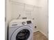 Laundry area featuring a white front-load washing machine, tile flooring, and a wire shelving unit at 11426 Savannah Creek Dr, Charlotte, NC 28273