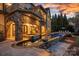 An evening view of the backyard featuring a pristine pool, jacuzzi, and elegant outdoor seating at 122 N Longfellow Ln, Mooresville, NC 28117