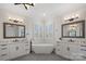 A bright bathroom features a large soaking tub, and vanities, and shuttered windows at 122 N Longfellow Ln, Mooresville, NC 28117