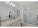 A well-lit bathroom features a vanity with marble countertops, a glass-enclosed shower, and ample lighting at 122 N Longfellow Ln, Mooresville, NC 28117