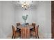 Elegant dining room with a round table, six wicker chairs, chandelier, and tray ceiling at 122 N Longfellow Ln, Mooresville, NC 28117