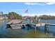 Lakeside dock featuring a boat lift and an outdoor dining area perfect for enjoying the water at 122 N Longfellow Ln, Mooresville, NC 28117