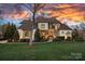 Stunning stone and siding home boasts lush landscaping and a captivating sunset backdrop at 122 N Longfellow Ln, Mooresville, NC 28117