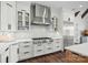 Sleek, modern kitchen with white cabinetry, stainless steel appliances and herringbone tile backsplash at 122 N Longfellow Ln, Mooresville, NC 28117