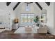 Bright living room boasts vaulted ceilings, beams, large windows with lake views, and sleek furnishings at 122 N Longfellow Ln, Mooresville, NC 28117