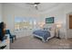 Main bedroom featuring a large bed, lake view, plenty of natural light, and tray ceiling at 122 N Longfellow Ln, Mooresville, NC 28117