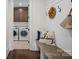Mudroom with bench seating, coat hooks, decor, and a view to the laundry room with washer and dryer at 122 N Longfellow Ln, Mooresville, NC 28117