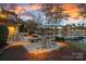 Outdoor patio with a firepit, lake views, and beautiful landscaping at 122 N Longfellow Ln, Mooresville, NC 28117