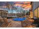 Backyard pool with lake views and patio area at sunset at 122 N Longfellow Ln, Mooresville, NC 28117