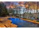 Inviting pool area with serene lake views, lounge seating, and artistic stone accents at 122 N Longfellow Ln, Mooresville, NC 28117