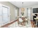 Bright dining area with a modern light fixture, a table set for four, and natural light from windows and a door at 137 Woodbridge Cir, Mount Holly, NC 28120