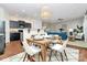 Open-concept dining area features a stylish light fixture, seating for four, and flows into the kitchen and living room at 137 Woodbridge Cir, Mount Holly, NC 28120