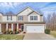 Charming townhome with a two-car garage, landscaped yard, and a welcoming front porch on a sunny day at 137 Woodbridge Cir, Mount Holly, NC 28120