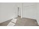 Bright bedroom with neutral carpet, white walls, closet, and open doorway at 13705 Roderick Dr # 194, Huntersville, NC 28078