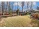 Landscaped backyard with lush lawn, mature trees, and outdoor seating area, perfect for entertaining and relaxation at 14827 Batteliere Dr, Charlotte, NC 28278