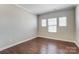 This bedroom has three windows offering natural light, showcasing its hardwood floors at 14827 Batteliere Dr, Charlotte, NC 28278