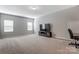 Open Bonus room with neutral colored carpet, tv, and dual windows at 14827 Batteliere Dr, Charlotte, NC 28278