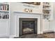 Living room fireplace with stone hearth and decorative mantel, flanked by built in shelving at 14827 Batteliere Dr, Charlotte, NC 28278