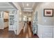 Hallway with hardwood floors and decorative molding offering views into multiple rooms at 14827 Batteliere Dr, Charlotte, NC 28278
