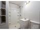 Bathroom includes white shower, sink, toilet, open shelves and light fixture at 1501 Fern Forest Dr, Gastonia, NC 28054