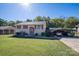 Exterior of a two-story home with yellow siding, red shutters, green lawn and a covered parking area at 1501 Fern Forest Dr, Gastonia, NC 28054