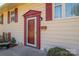 Charming front door with red trim, house number, and red shutters on a light yellow home at 1501 Fern Forest Dr, Gastonia, NC 28054